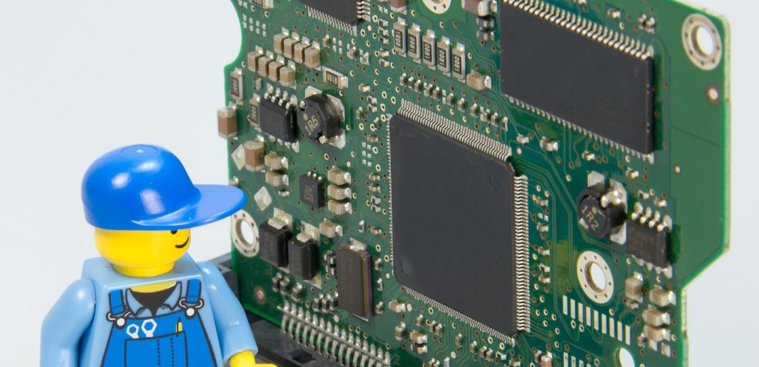 A small figurine resembling an electrician next to a green printed circuit board (PCB), troubleshooting and management of electronic components for 3D collision and clearance checks in PCB design