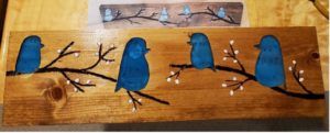 Four blue birds perched on branches carved into a wood plaque created by Chuck Applications Engineer Zuken