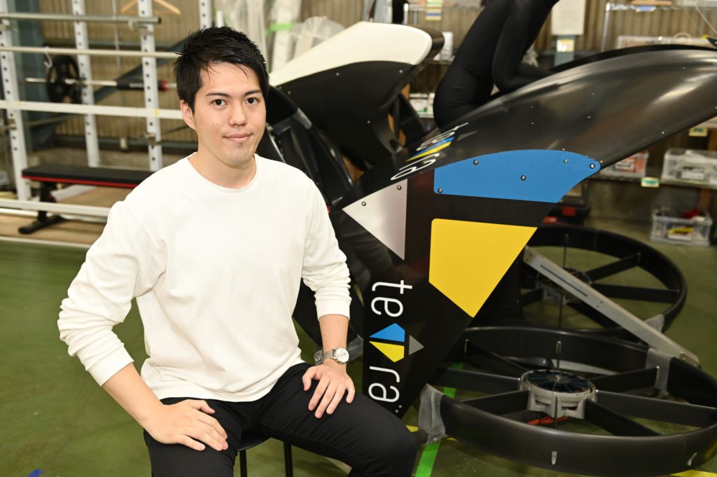 Man sitting next to a flying car