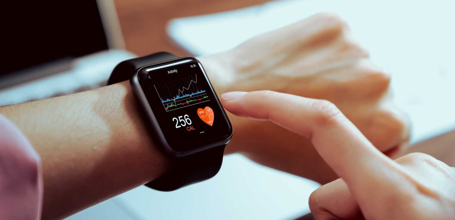 Wearable technology - Close-up of hand touching a smartwatch showing a health app on the screen.