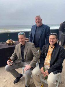 Three men smiling and posing for a picture.