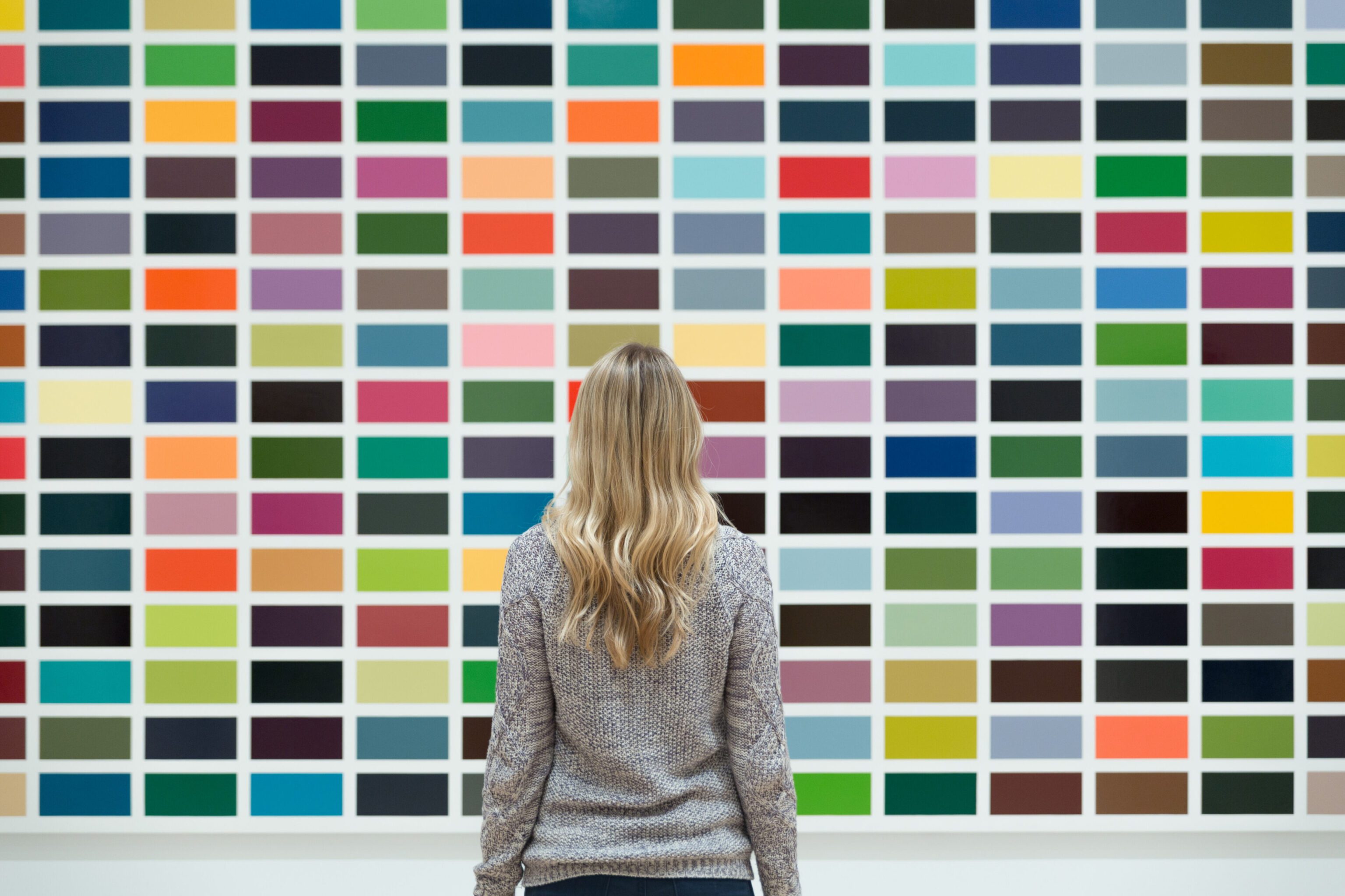 View from behind a woman looking at a large pane of many colors