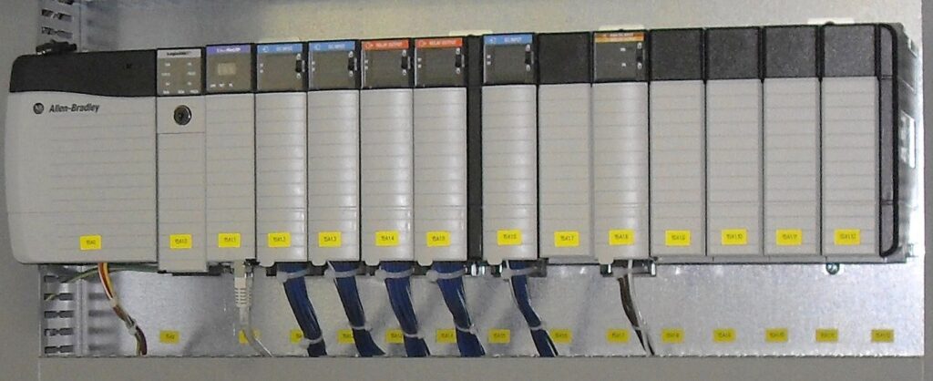 Rack-mounted programmable logic controller (PLC) with CPU and I/O modules installed inside an electrical control cabinet.