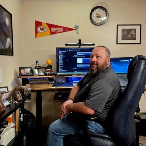 Mike Bayliff seated at his desk in his home office.